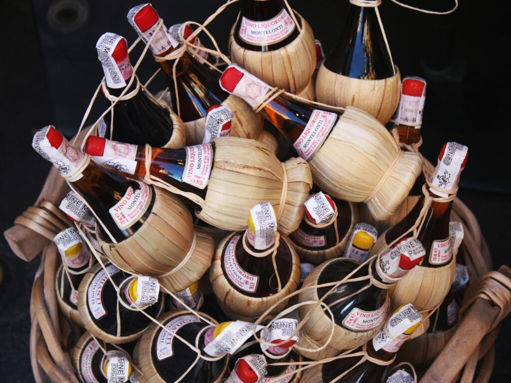 Wine Story Born in the Heart of Tuscany | Geografico Authentic Tuscan Chianti wine bottles in traditional straw fiasco baskets from Florence, Italy.